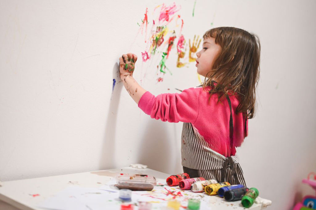 Fillette qui dessine sur les murs