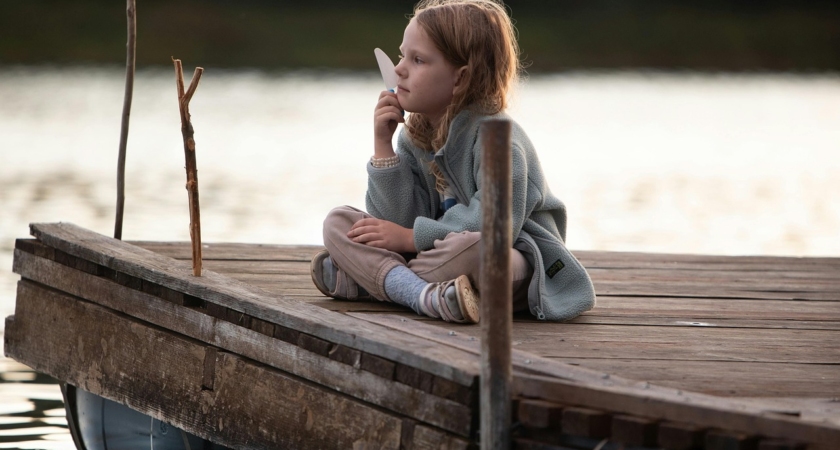 Fillette seule pensive sur un ponton