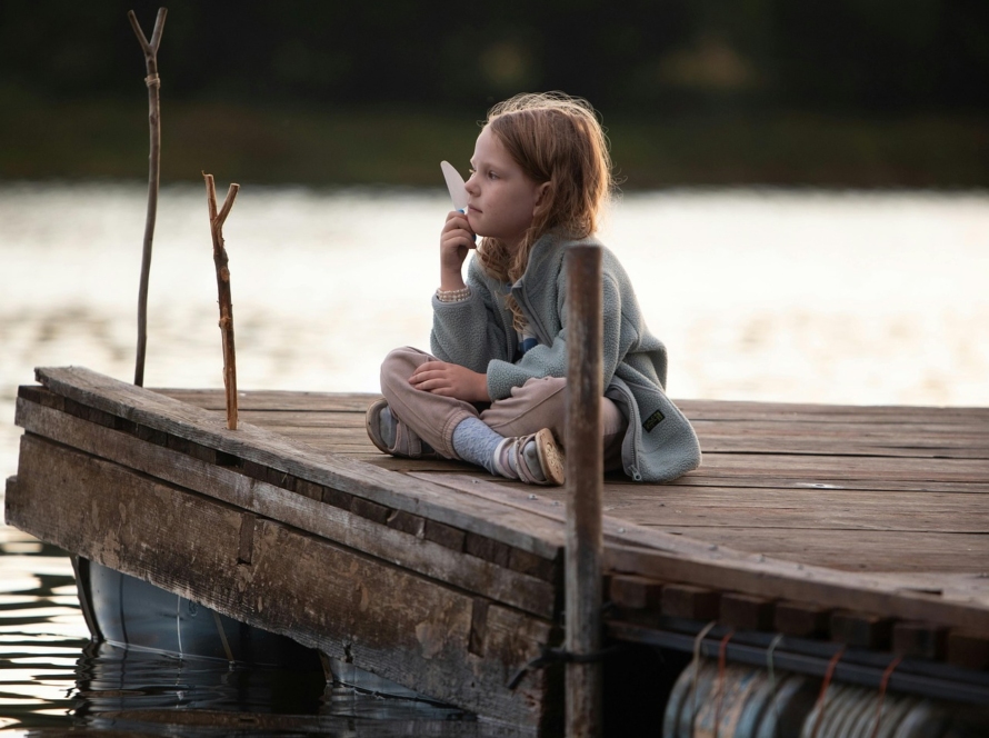 Fillette seule pensive sur un ponton