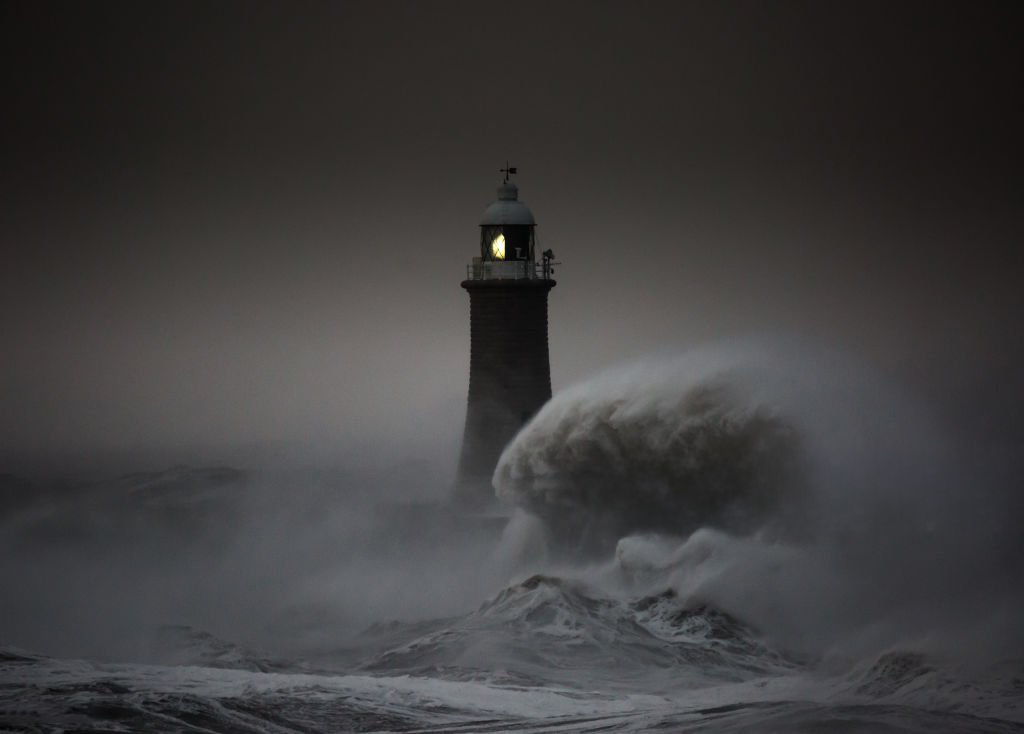 Un phare dans la nuit en proie aux vagues
